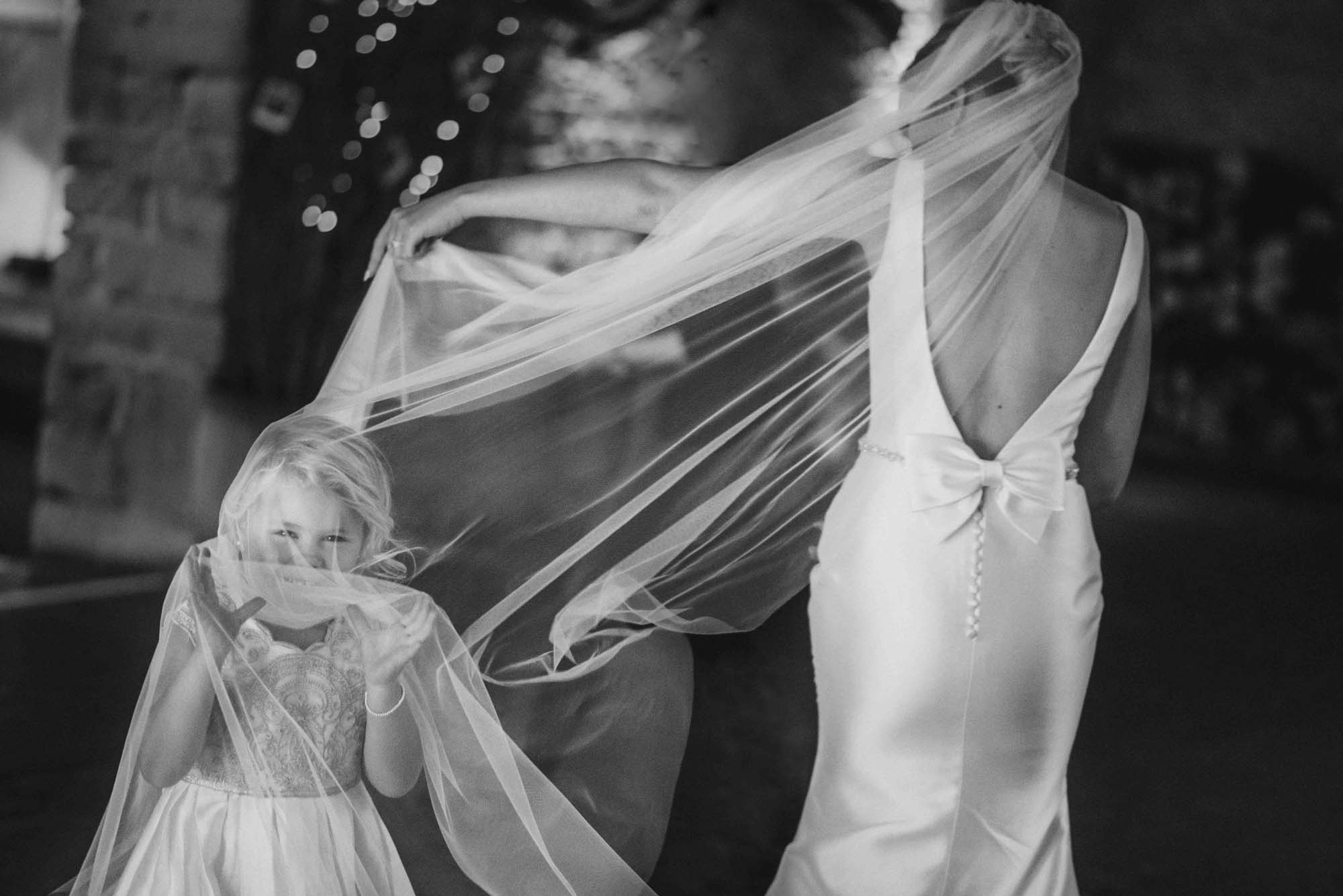Flower girl playing in Bride Veil Photo 